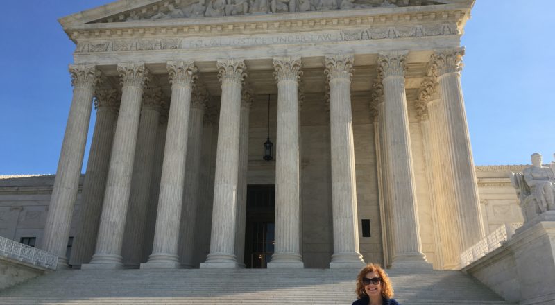 woman standing by the steps of the Supreme Court building