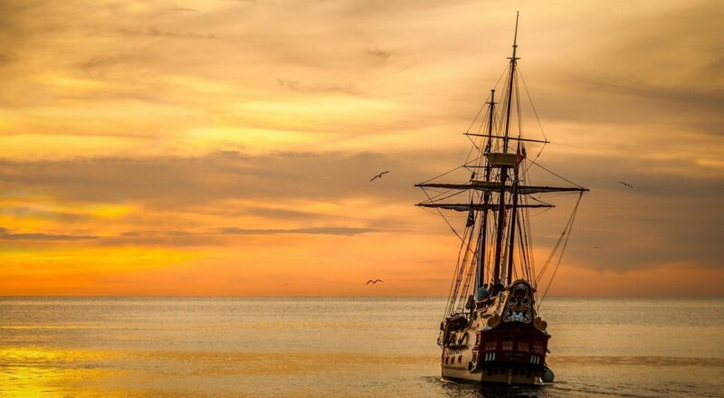 Columbus' boat on ocean at sunrise
