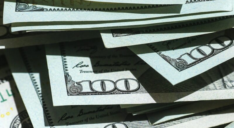 $100.00 bills scattered to show risk/reward