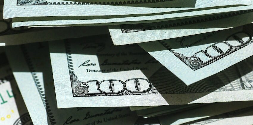 $100.00 bills scattered to show risk/reward