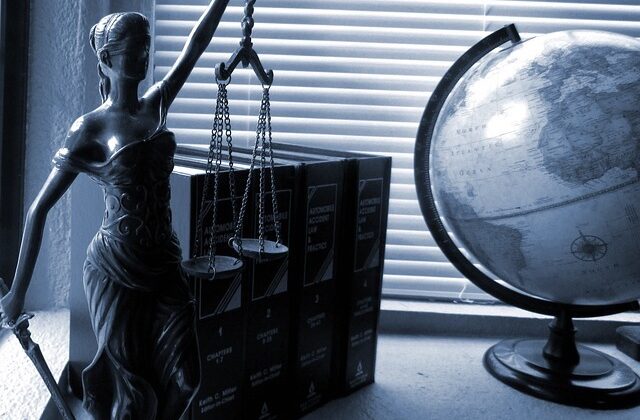 Lady Justice on a desk with a globe nearby